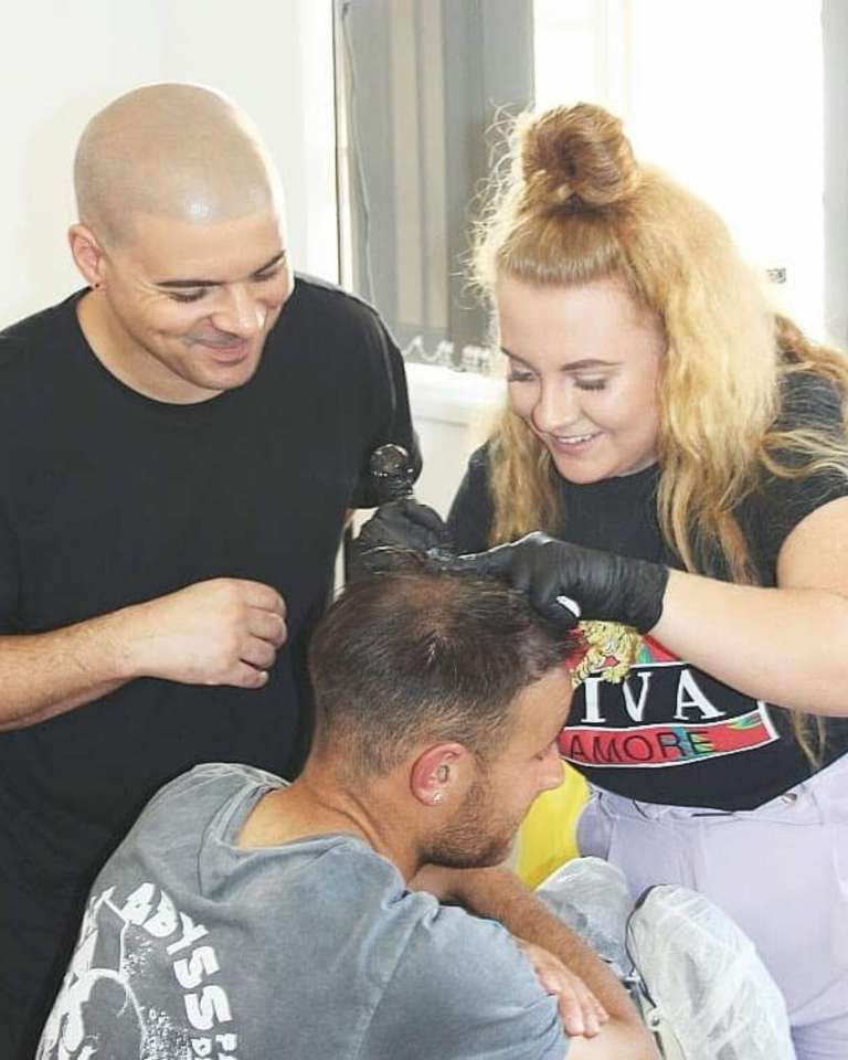 Trainees practising scalp micropigmentation on a live model under supervision on the Scalp Culture training course